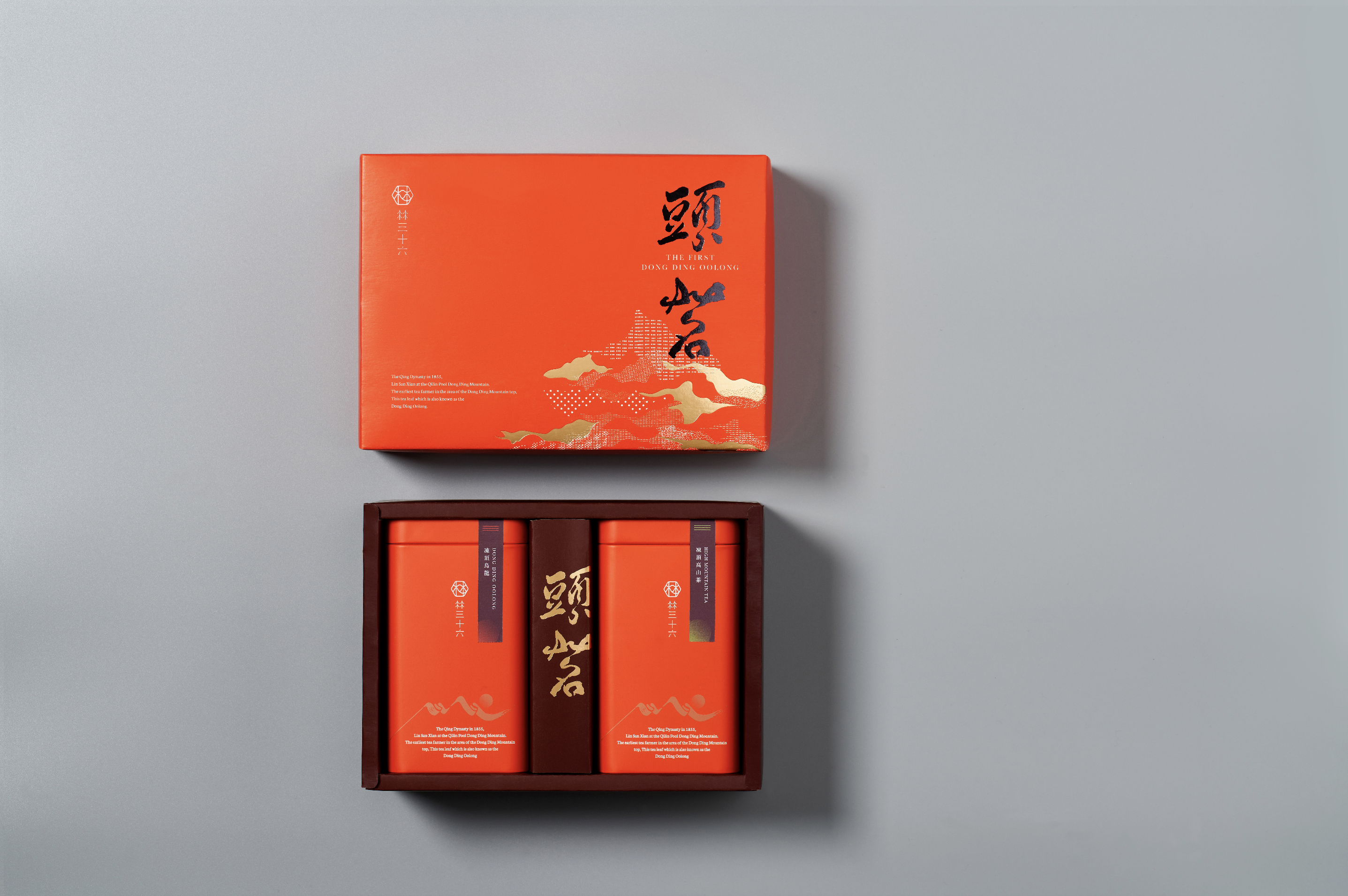 旭利紙器為「林三十六」設計的凍頂茶禮盒，採用大膽的橘紅色調與燙金山水圖案，展現高端大氣的包裝質感。這款書型禮盒的結構穩固，能完美收納兩罐茶葉鐵罐，是品牌包裝與送禮推薦的精緻範例，成功塑造專業形象。